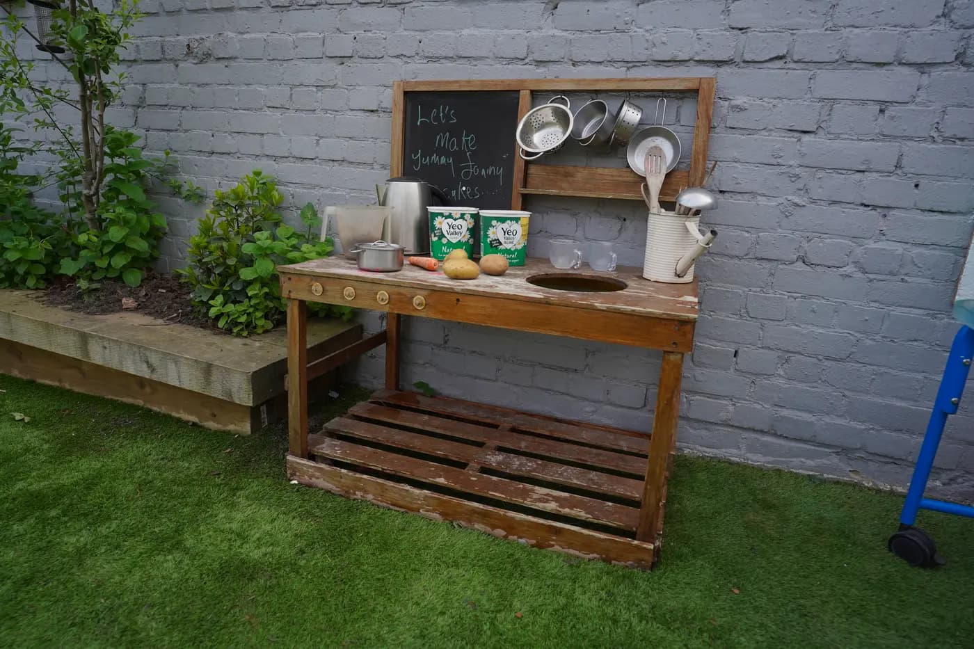 Outdoor mud kitchen with chalkboard menu at Blue Nest Borehamwood