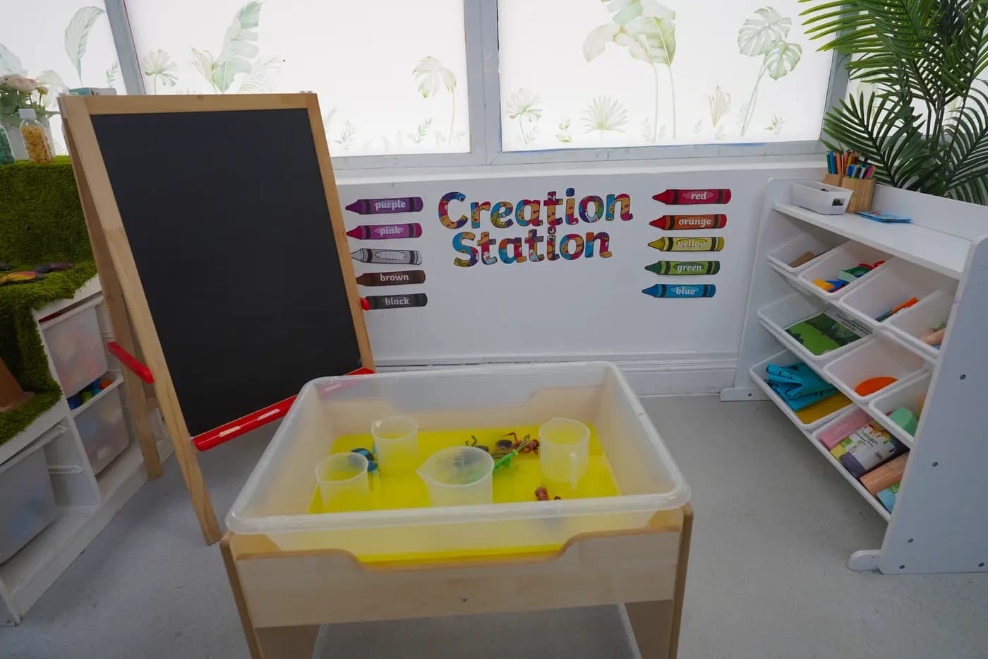 Creation Station art area with chalkboard and crayon labels at Blue Nest Borehamwood