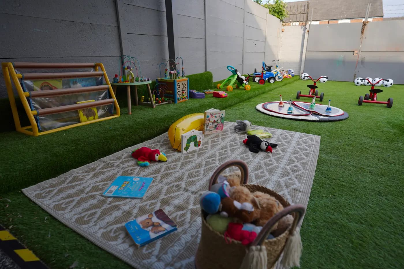 Outdoor reading rug with picture books and soft toys at Blue Nest Borehamwood