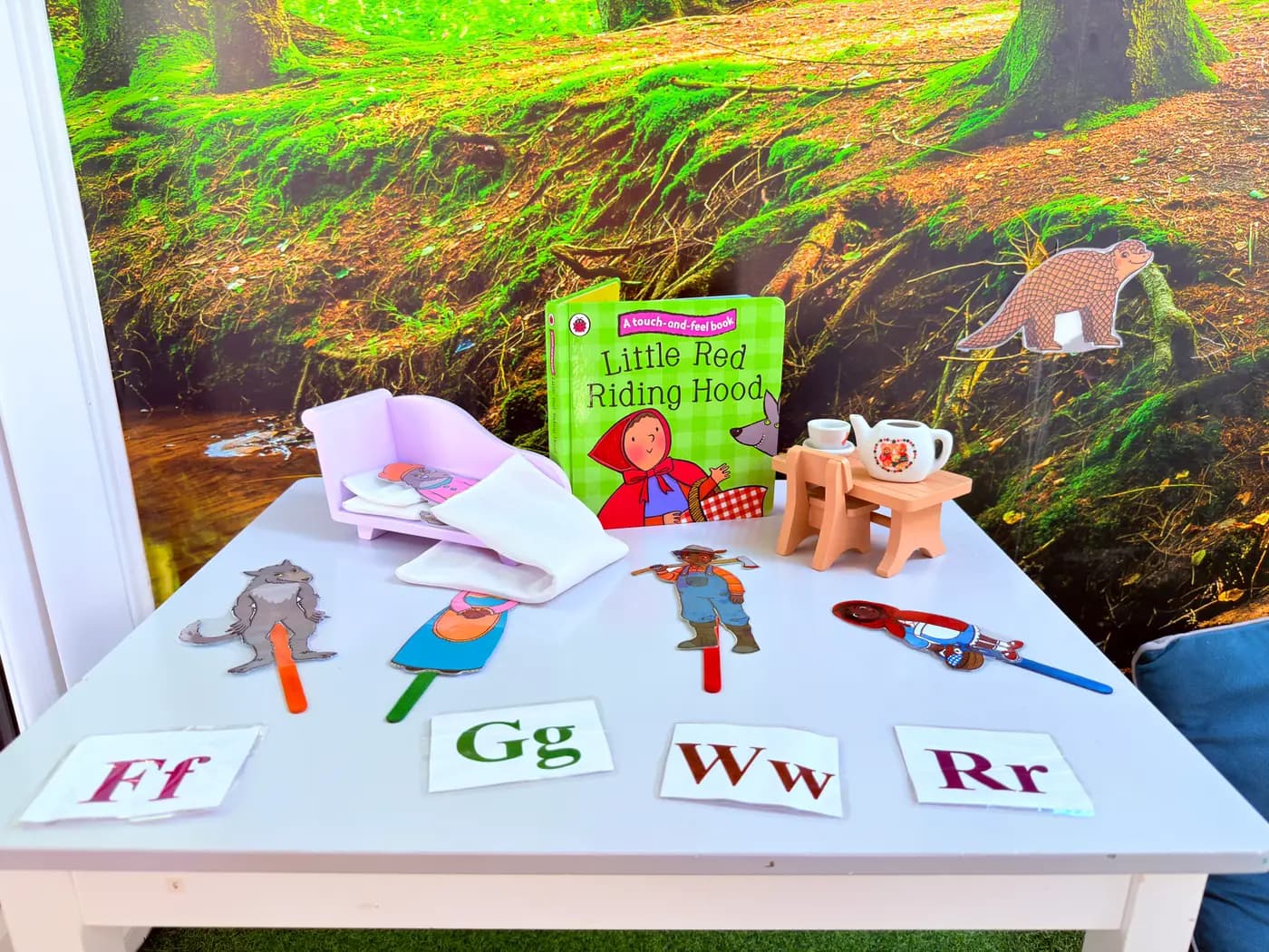 Storytelling table at Blue Nest Montessori Harrow with Little Red Riding Hood book and Montessori letter cards