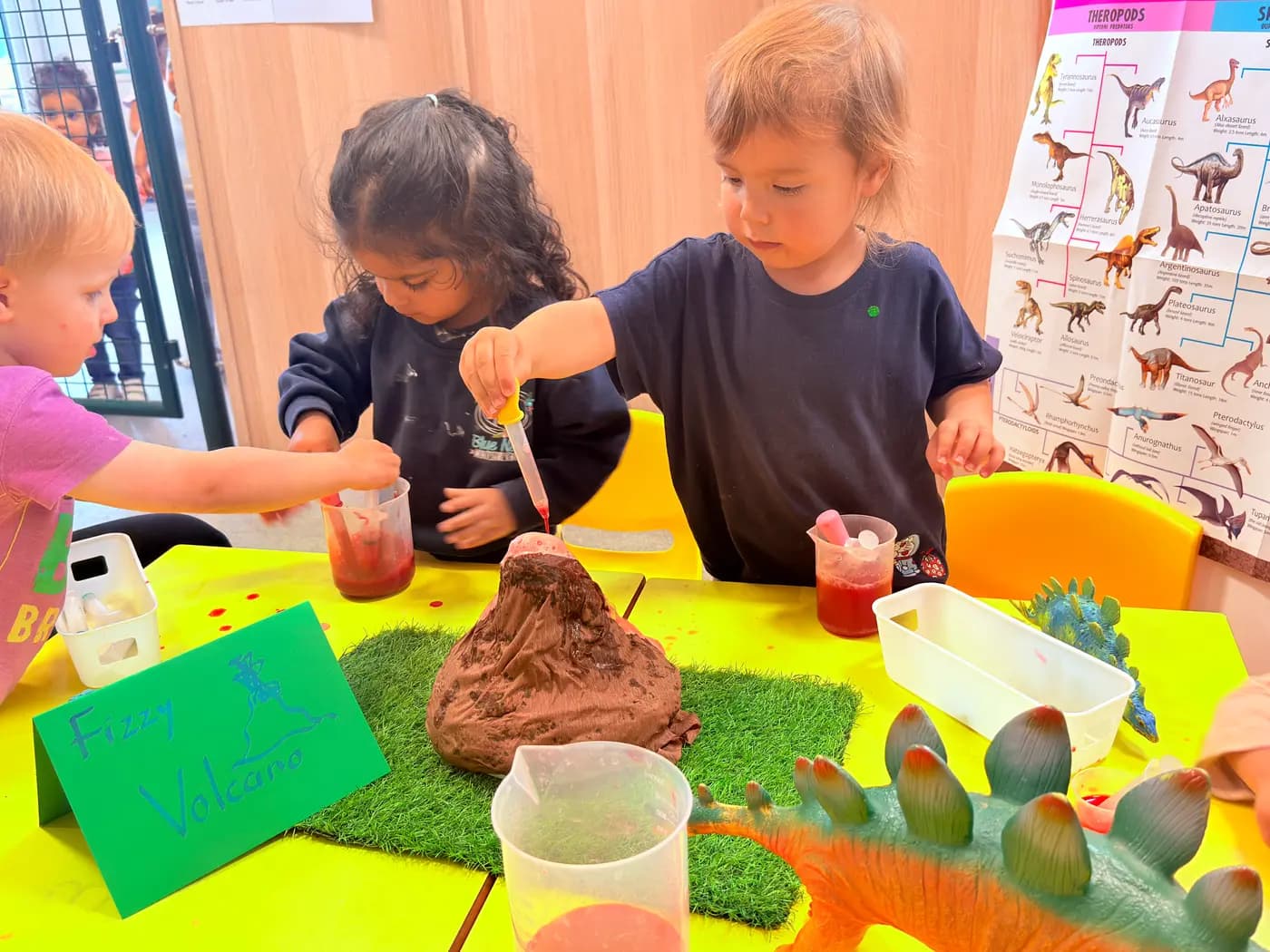 Three children running a fizzy volcano science experiment at Blue Nest Montessori Harrow