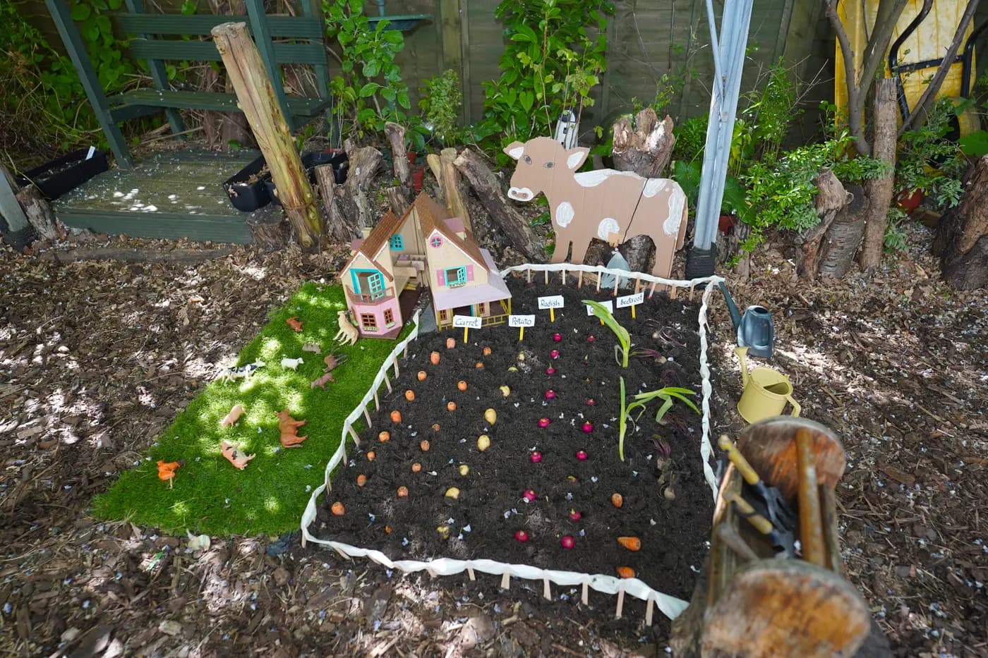 Outdoor miniature village and animal models in the Blue Nest Pinner garden